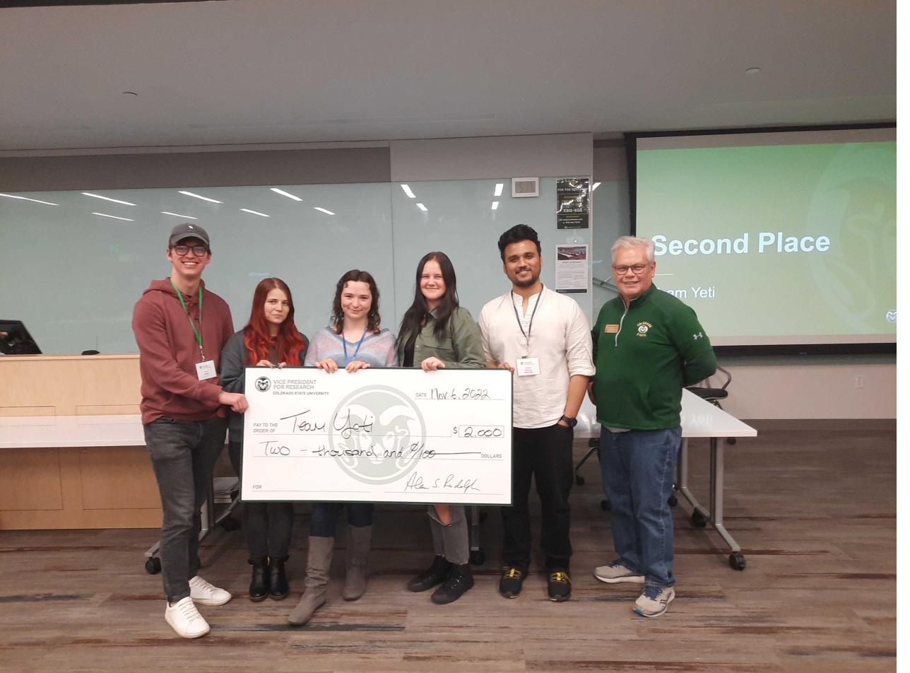 Five students holding a large second-place ceremonial check for Team Yeti at the 2022 CSU VR Hackathon awards.